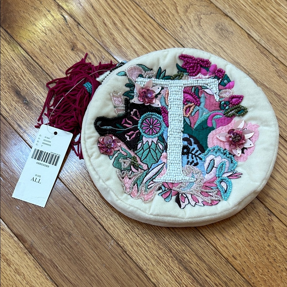 Anthropologie Cream Round Wristlet with Fuchsia Tassel